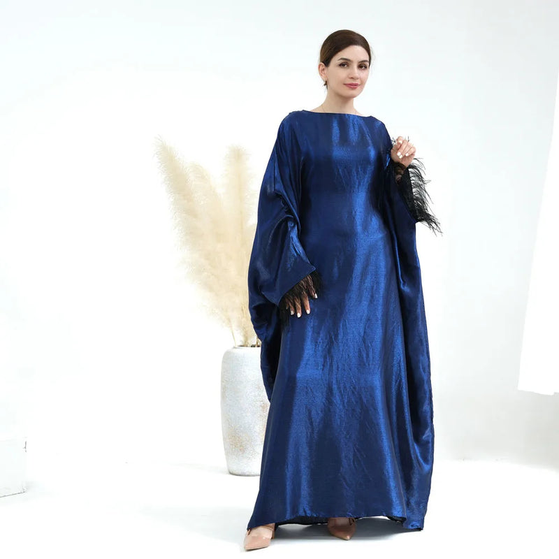 The Farha Feather Batwing Sleeve Maxi Dress is the dress of this year. Glimmer and sparkle with batwing long sleeve abaya maxi dress with feather detailing. Waist belt is tightened from the inside. 