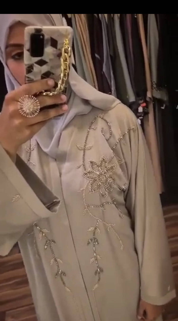 A luxury abaya with embellished gold crystals that cascade down the front of the garment.