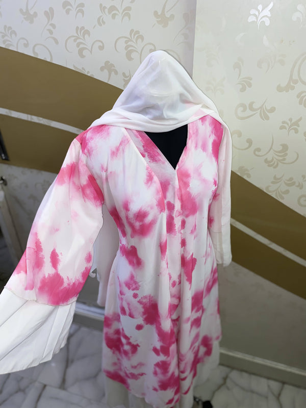 A three layered tie-dye abaya in white and pink. This closed abaya includes a white hijab and a belt for fitting. 