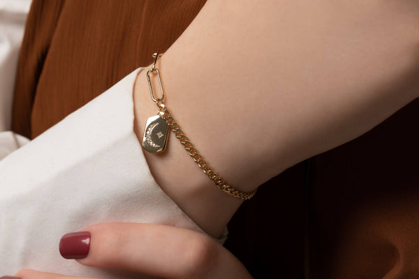Moon and star locket ono bracelet with gold link chain.