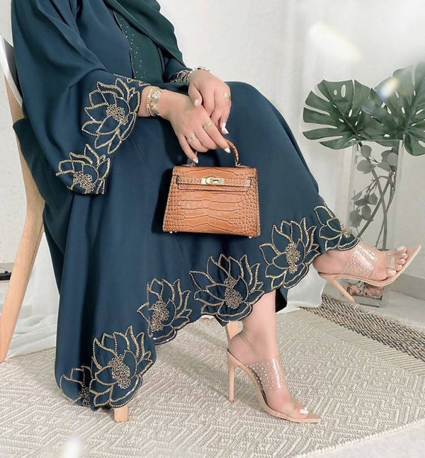 Show up to work looking stylish in this beautiful abaya with embroidery and diamond details on the front!
