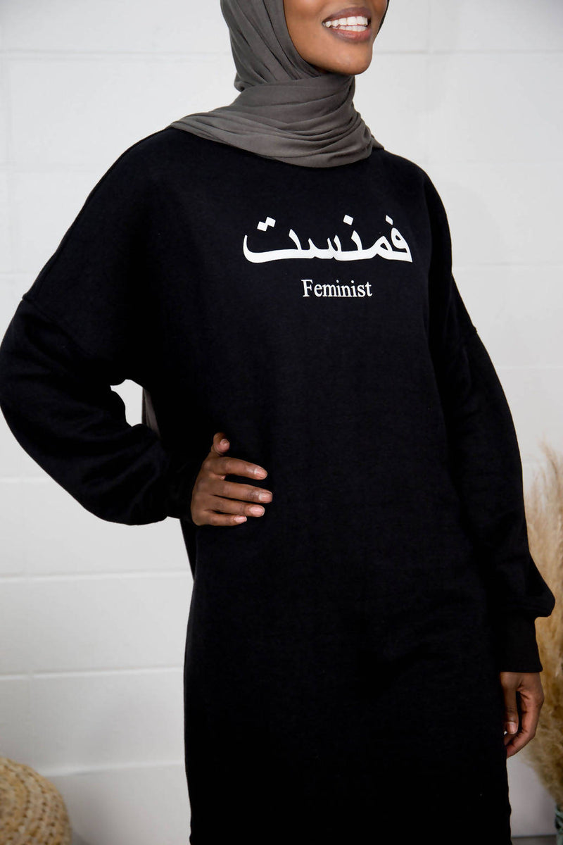 Woman wears black Feminist Sweater 